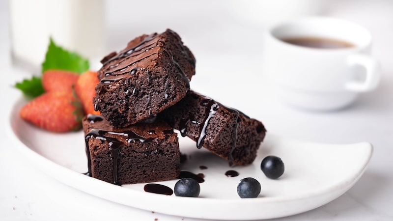 Homemade brownie cake on the white plate looks appetizing.
